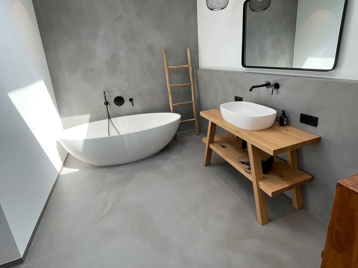 Bad mit freistehender Wanne, Wand und Boden fugenlos in grauem Mikrozement